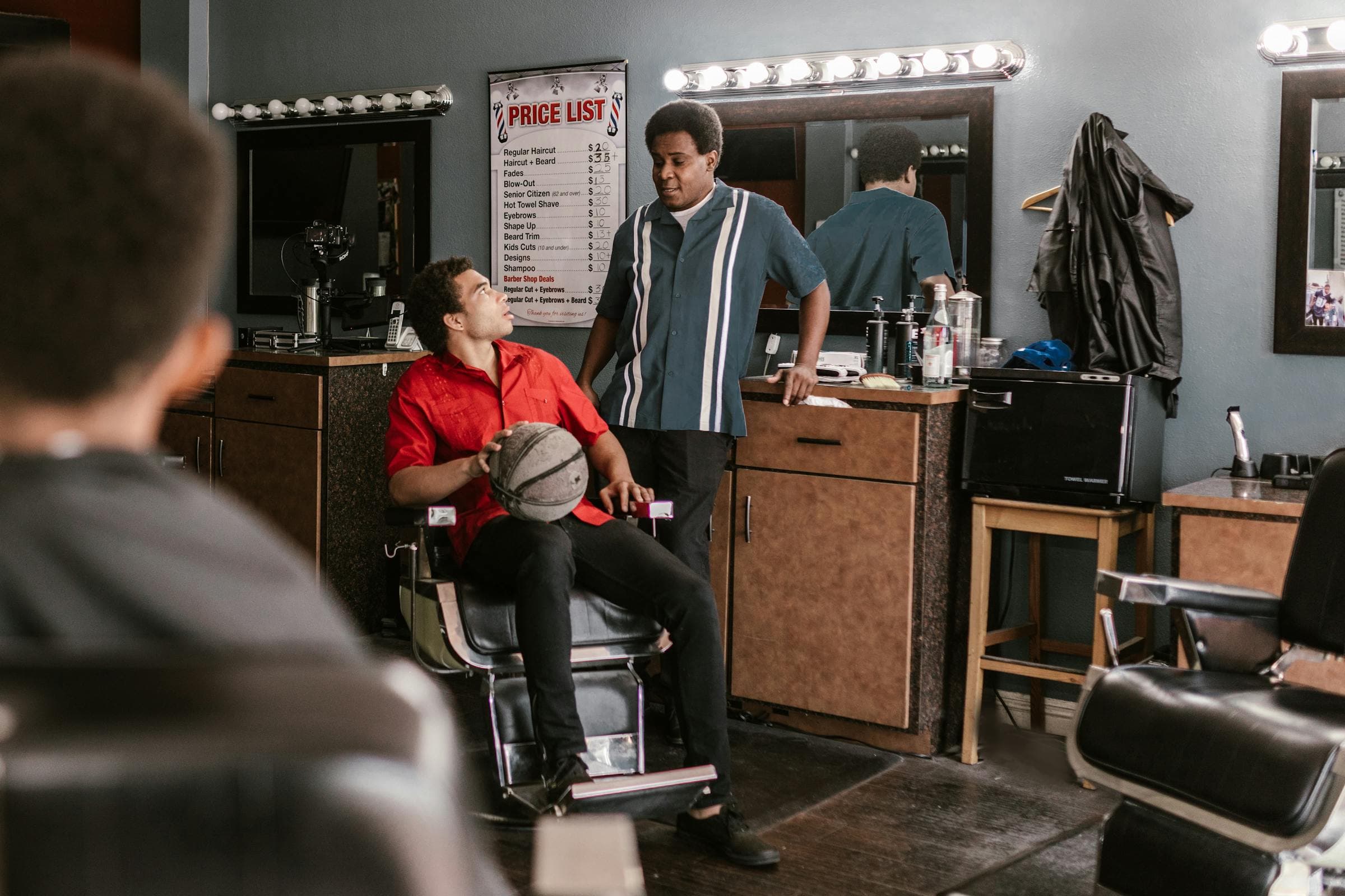 Barberia elegante con clientes y equipo trabajando.